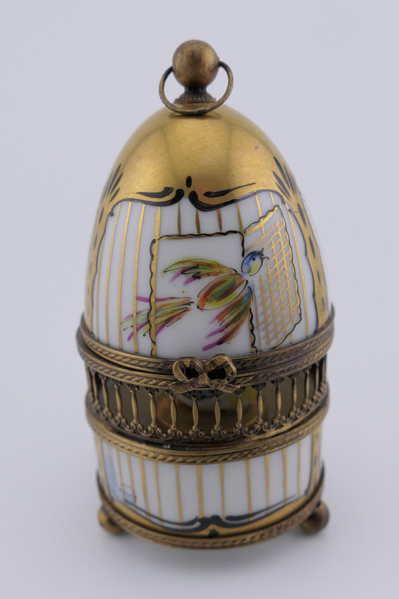 Limoges Porcelain Bird Cage Trinket Box: Limoges hand painted porcelain hinged trinket box featuring a birdcage design with reticulated metal accenting and an attached bird figurine inside. Marked on the bottom Limoges France. Excellent cond