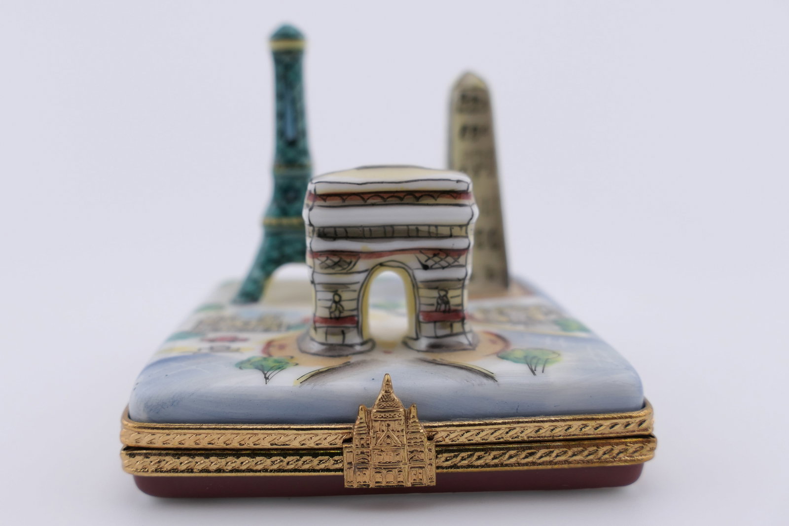Limoges Porcelain Parisian Landmark Trinket Box: Limoges hand painted porcelain hinged trinket box featuring a design of Parisian landmarks including the Arc De Triumph, The Eiffel Tower, and a Luxor Obelisk. Marked on the bottom Limoges France, Ren