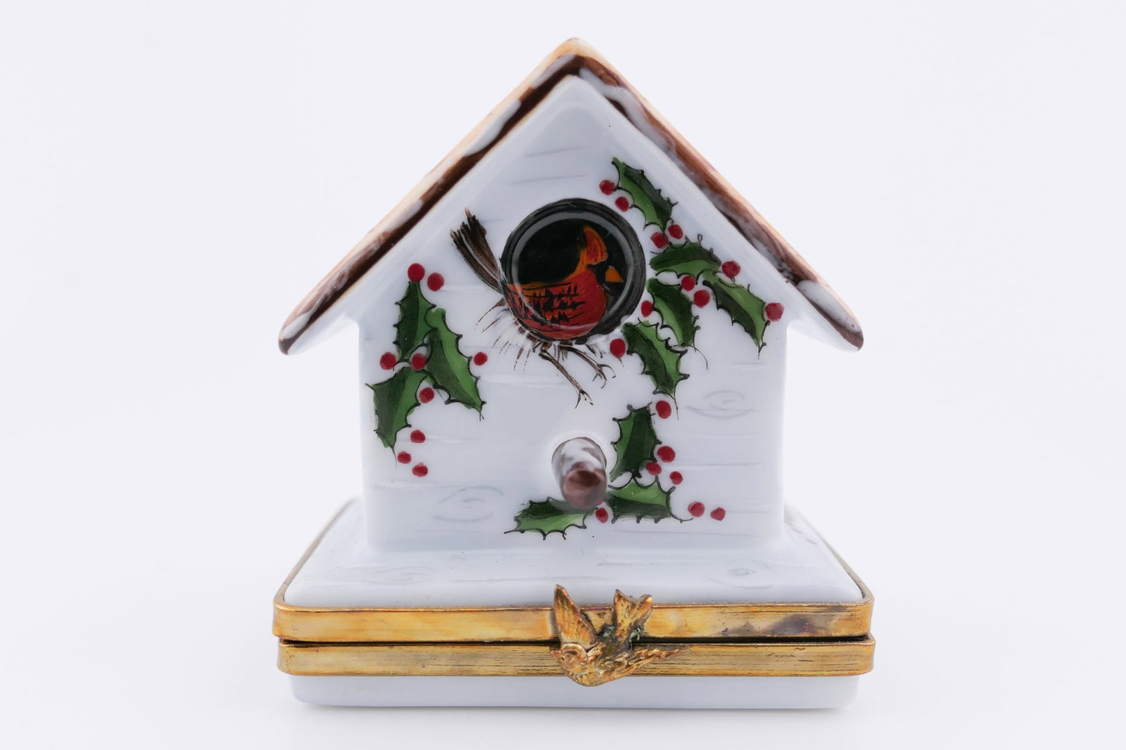 Limoges Porcelain Winter Birdhouse Trinket Box: Limoges hand painted porcelain hinged trinket box featuring a design of a wintery birdhouse with holly and cardinal motifs. Marked on the bottom Limoges France. Excellent condition. Size: 2"h Location