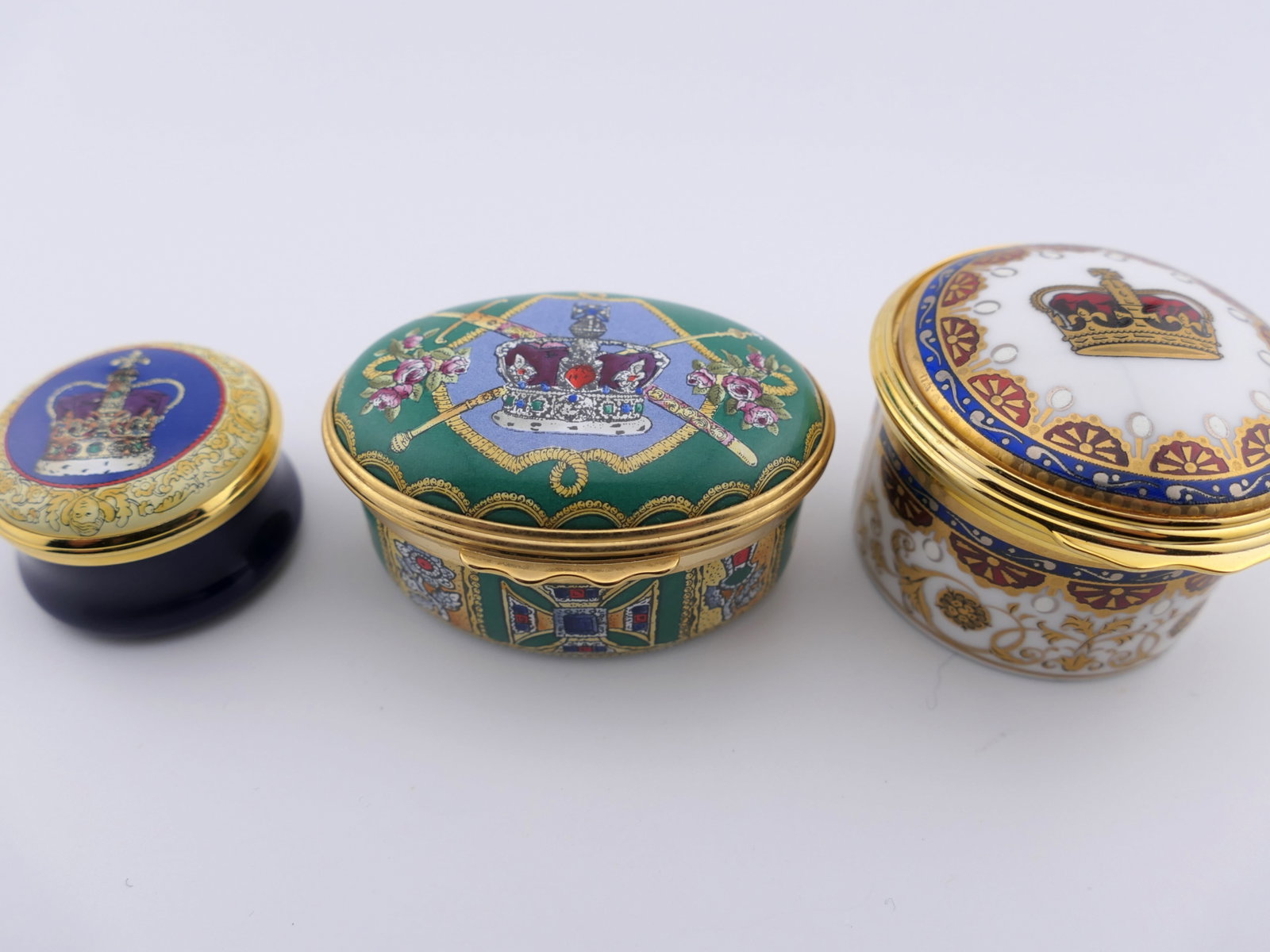 Three Jewel House Trinket Boxes: Three Jewel House trinket boxes with hinged and twist lids, two of which are marked for Halcyon Days, all featuring motifs of crowns for historic royal palaces. Excellent condition. Size: Largest 2"di