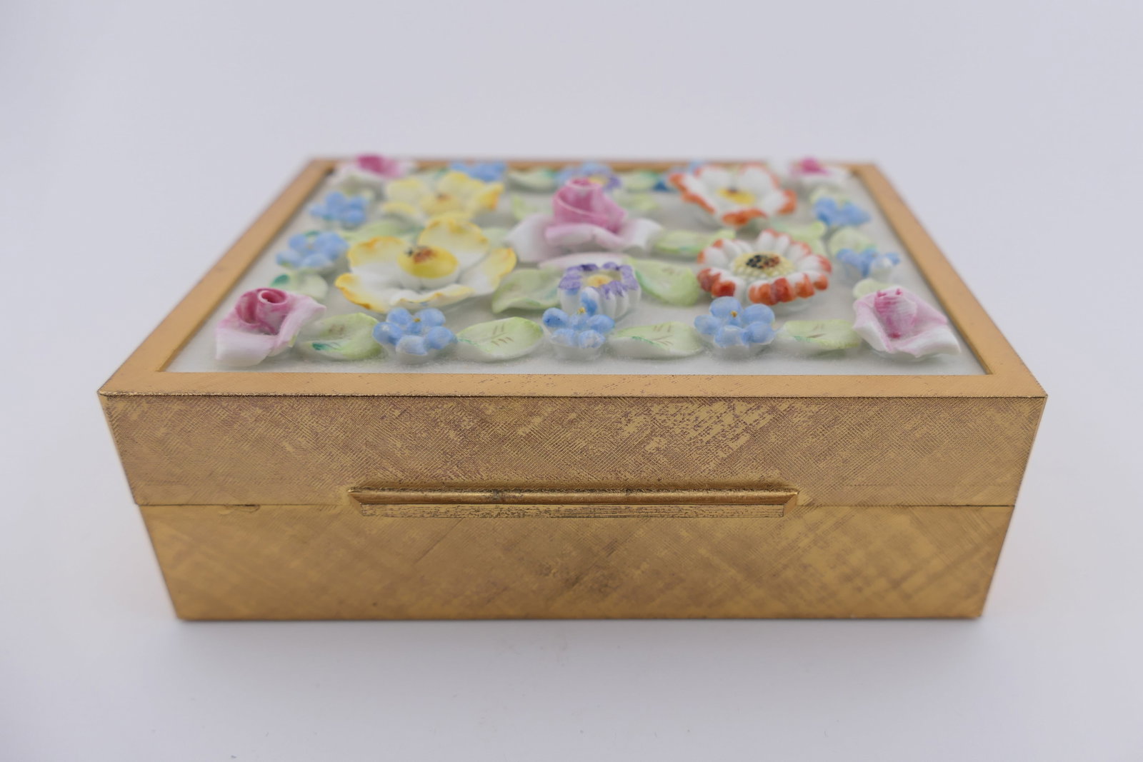 Italian Porcelain Trinket Box: Italian jewelry or trinket box marked Made in Italy for Bittner's, featuring a colorful porcelain floral relief plaque set into the lid. Marked inside the lid Made in Italy for Bittner's. Excellent co
