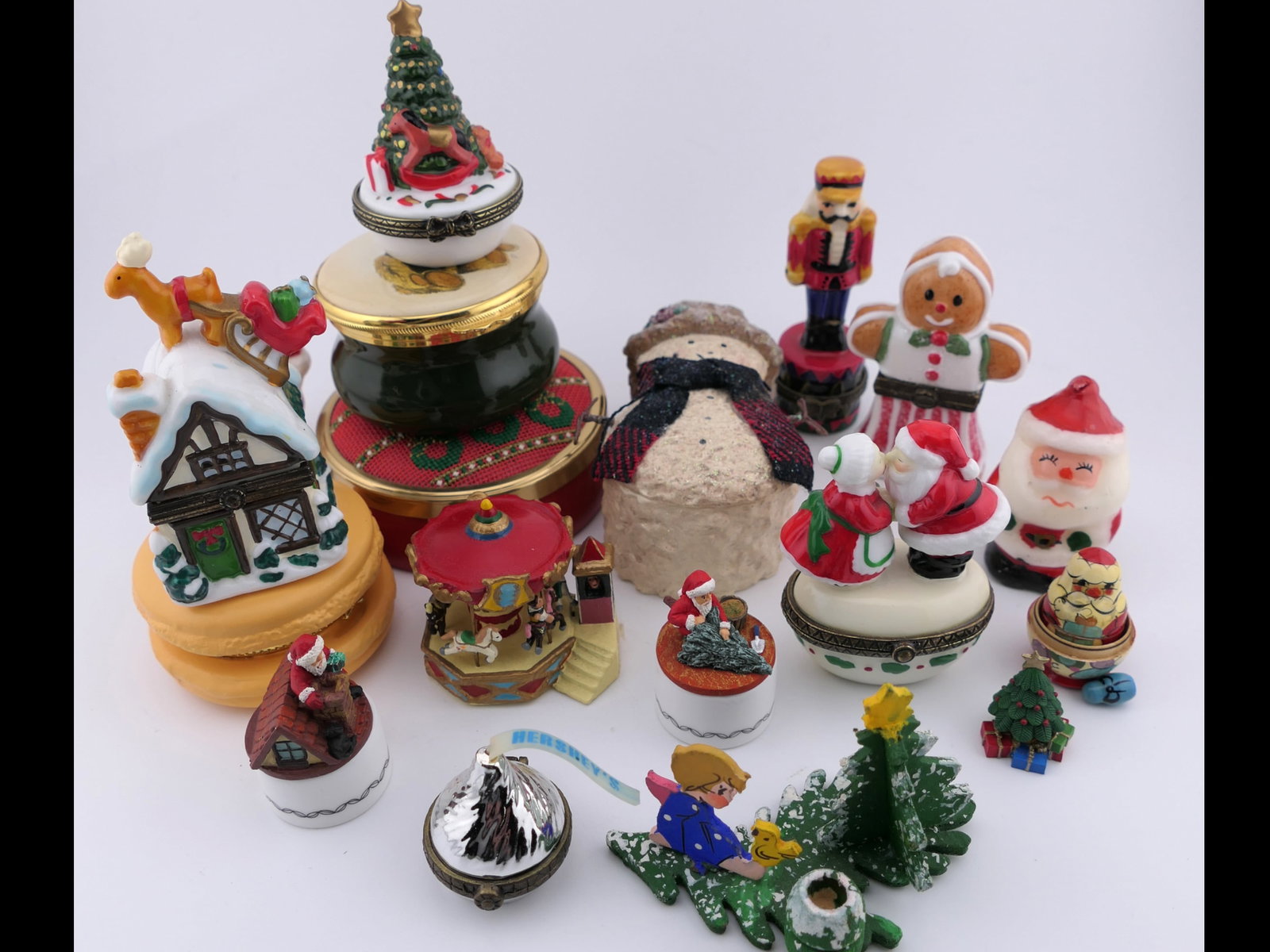 Christmas Trinket Box Collection: Collection of Christmas trinket boxes in a variety of styles such as a combination trinket box and jewelry piece, where the snowman lid can be used as a brooch (1998 Enesco), a Hershey's Kiss box