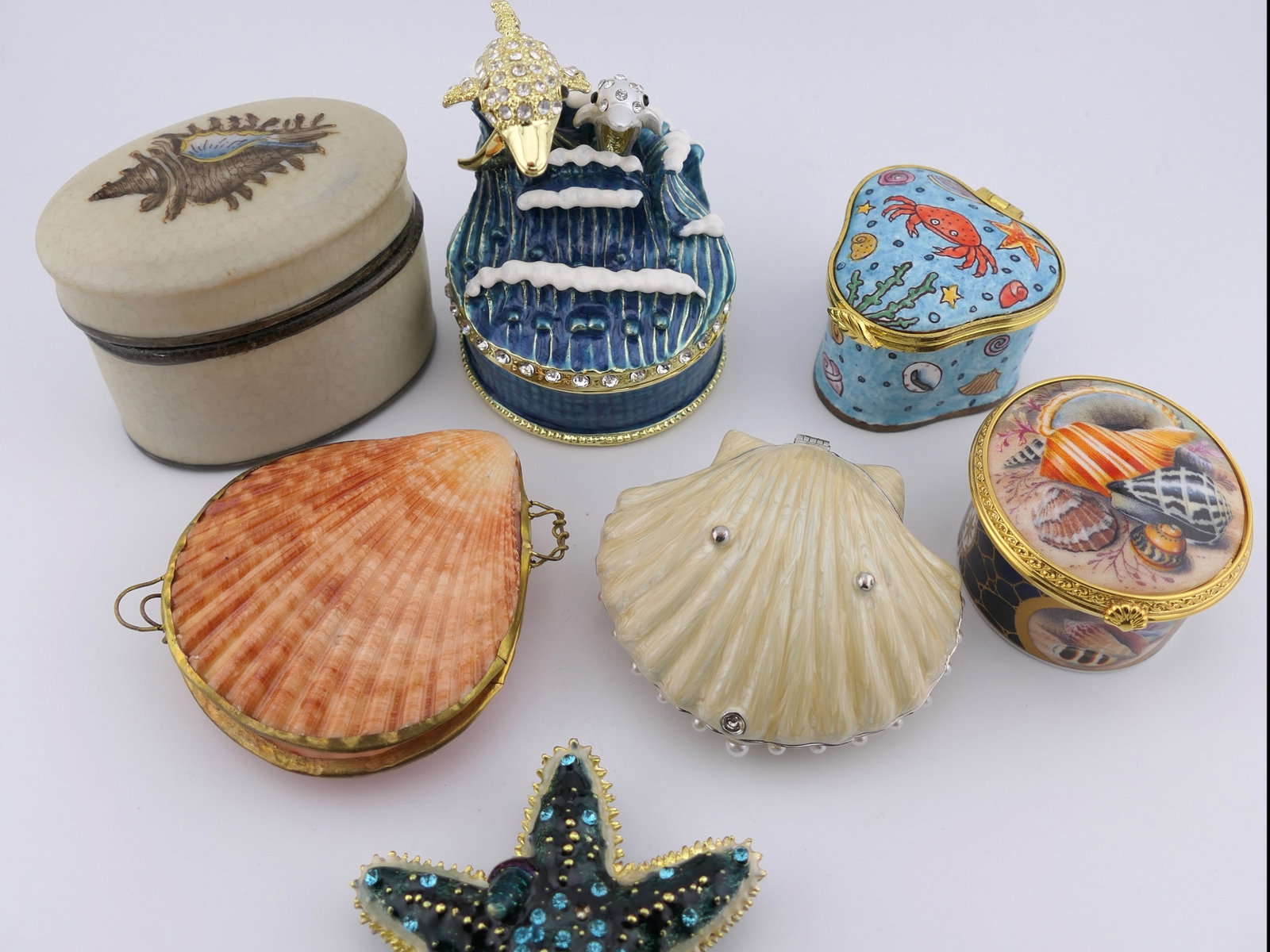 Beach Themed Trinket Boxes: Collection of beach themed trinket boxes including a Royal Worcester Connoisseur Collection shell trinket box, an Empress Arts enameled box, a blue starfish box with a magnet closure, a rhinestone