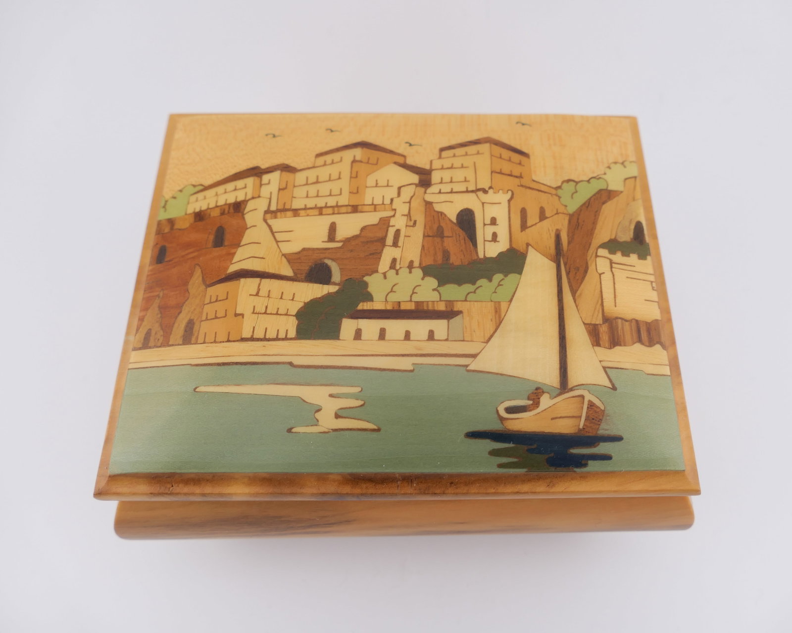 Unione Artigiani Music Box: Unione Artigiani Intarsio Sorrentio music box in wood construction with an inlaid marquetry scene in the lid depicting the coastline of Southern Italy. Plays when wound. Excellent condition. Size: