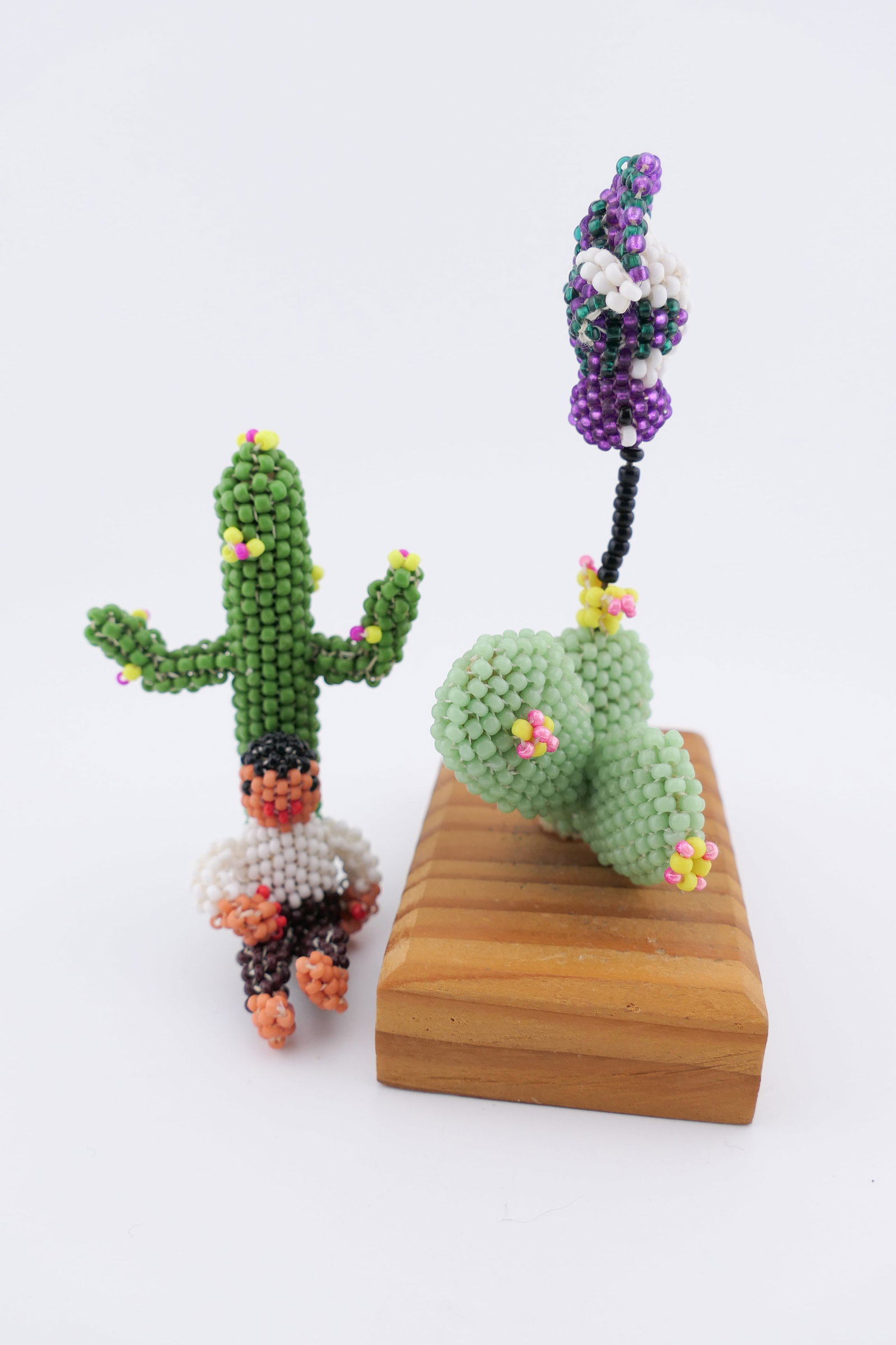 Two Farlan Quetawki Bead Art Figures: Two beaded folk art figures by Farlan Quetawki, a Zuni Pueblo Native American artist, depicting a flowering cacti. Both are artist signed on the bottom. Excellent condition. Size: 3"w x 1.75"d x 4"h