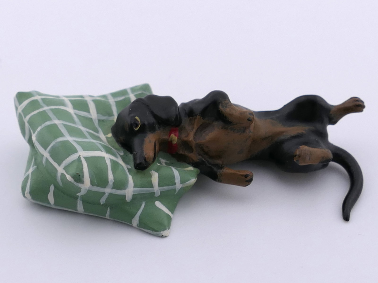 Fritz Bermann Wein Dachshund Bronze Figurine: Bronze figurine by Fritz Bermann Wein workshop depicting a cold-cast dachshund laying on a green check pillow, titled "Weiner Bronzen". Marked on the bottom FBW. Excellent condition. Size: 2"w x 1"l