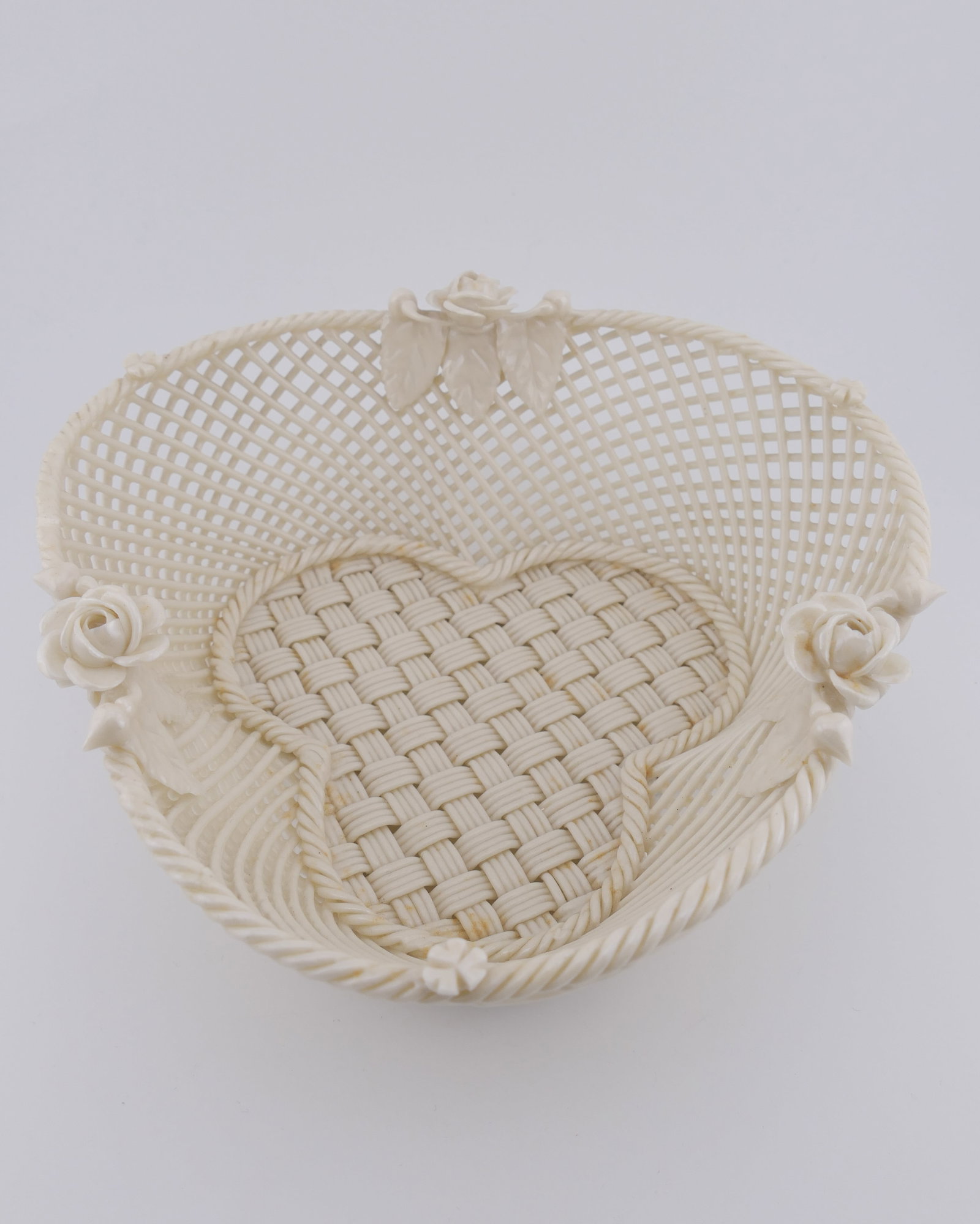 Belleek Porcelain Woven Basket: Belleek porcelain woven basket with shamrock shaped bottom with rose accents. Excellent condition. Size: 6.5"dia x 2.5"h Location: Living Room