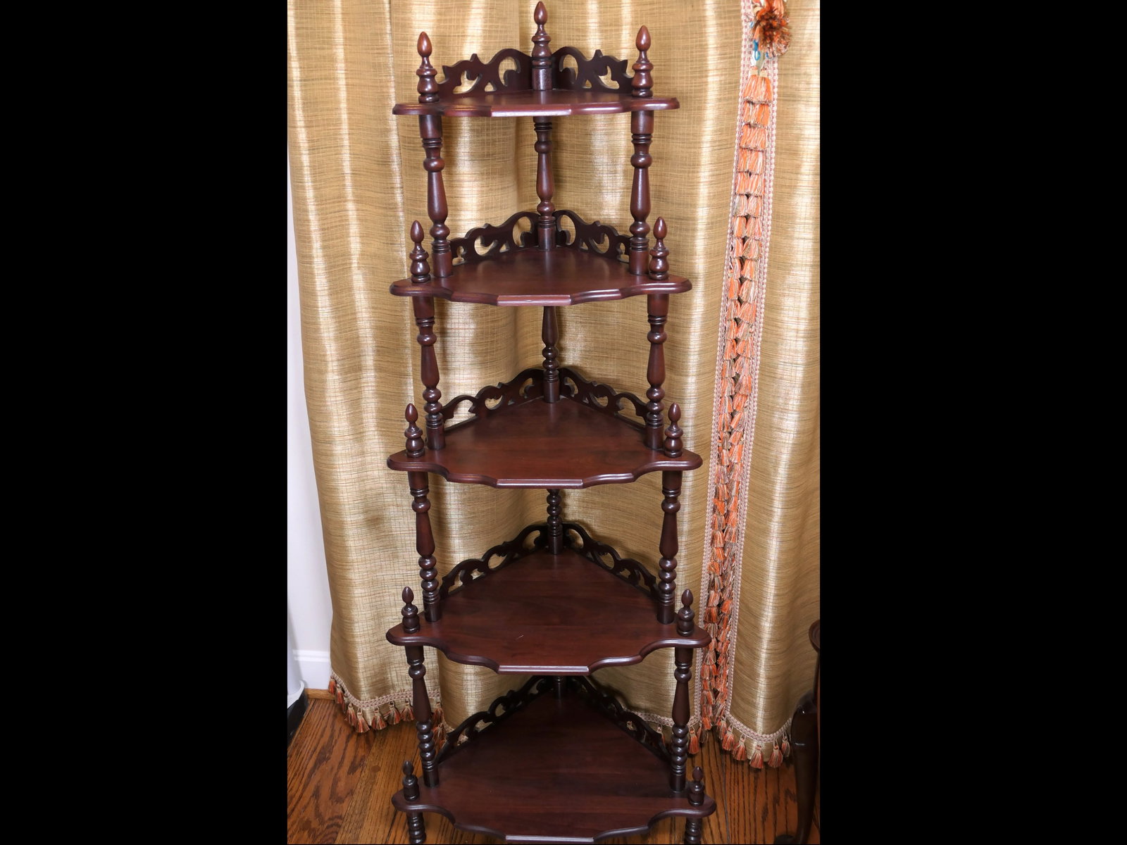 Victorian Style Corner What Not Shelf: Victorian style mahogany corner what not display stand with 5 graduated pie wedge shelves with pierced scroll design gallery and turned tier supports. Size: 24"w x 15"d x 4'11"h Location: Living Room
