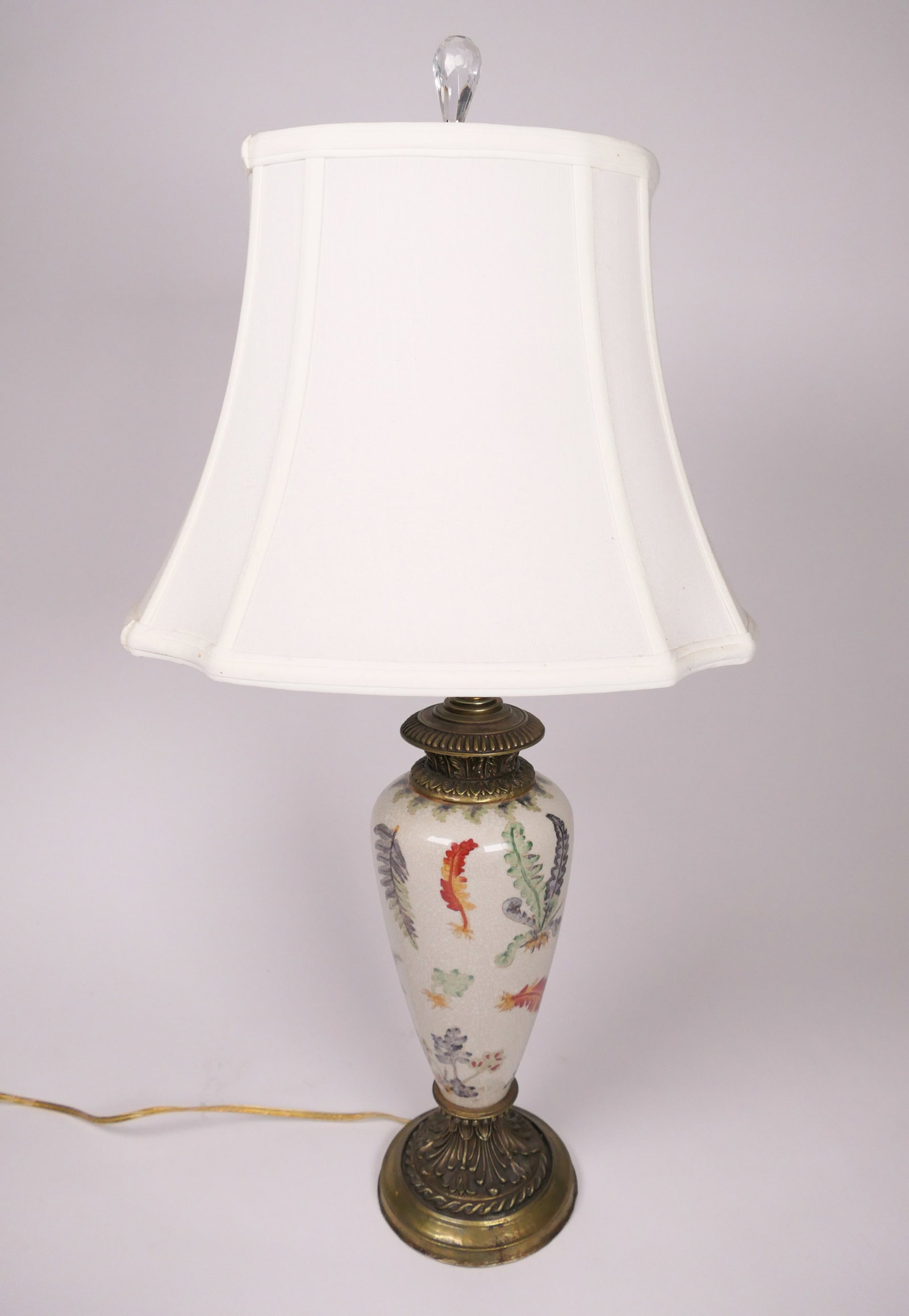 Porcelain and Brass Table Lamp: Porcelain and brass table lamp with painted leaf design, crazed surface and fabric shade. Lights. Size: 27"h Location: Living Room
