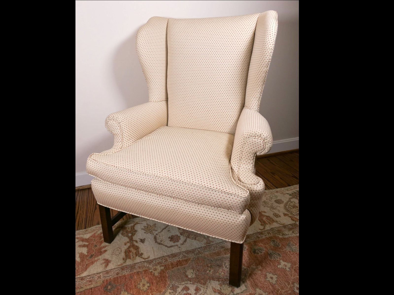 Chippendale Style Wingback Chair: Chippendale style straight leg wingback chair featuring a single loose seat cushion, scroll armrests, and ivory spotted upholstery fabric, all over walnut finish, straight legs and stretchers. Very