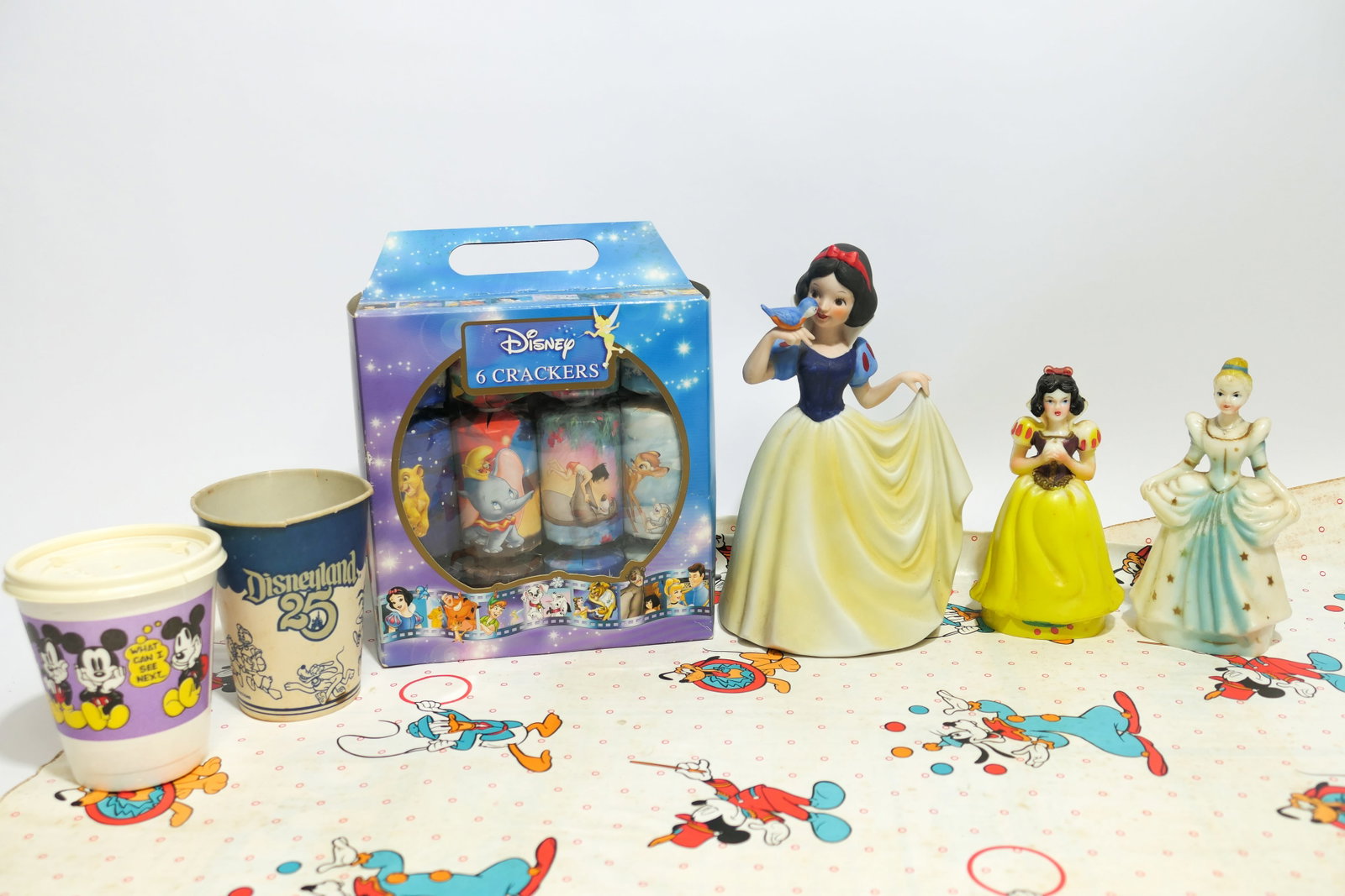 Vintage Disney Collectibles: Vintage Disney collectibles including a Walt Disney Snow White porcelain music box (does not work properly), 2 cake toppers depicting Snow White and Cinderella, Disneyland 25th anniversary paper cup