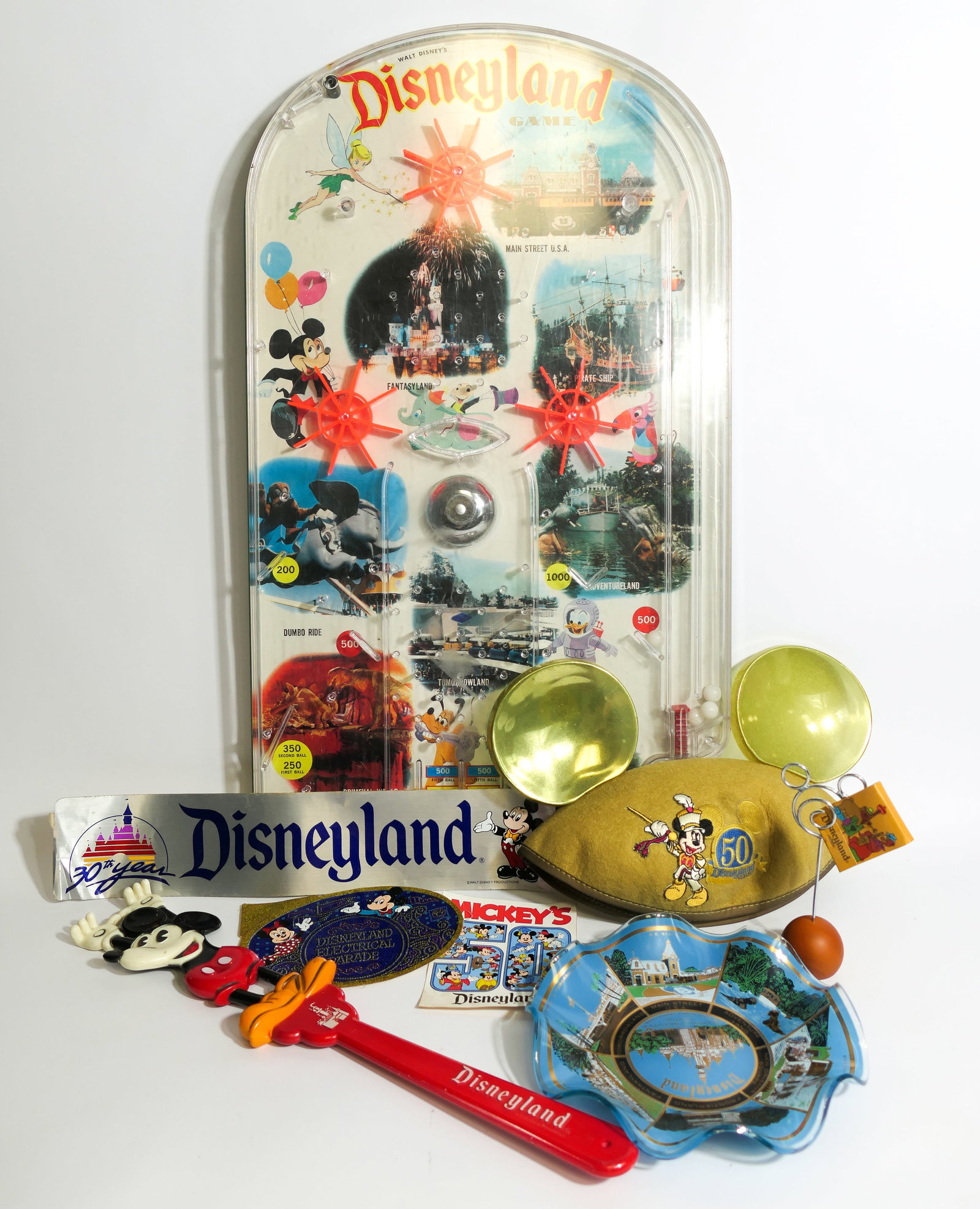 Wolverine Disneyland Pinball Game and Other Collectibles: Disneyland collectibles including a 1960's Disneyland tabletop pinball game by the Wolverine Toy Co., Mickey Mouse ear hat with a 50th anniversary pin, various unused Disneyland stickers, Disneyland