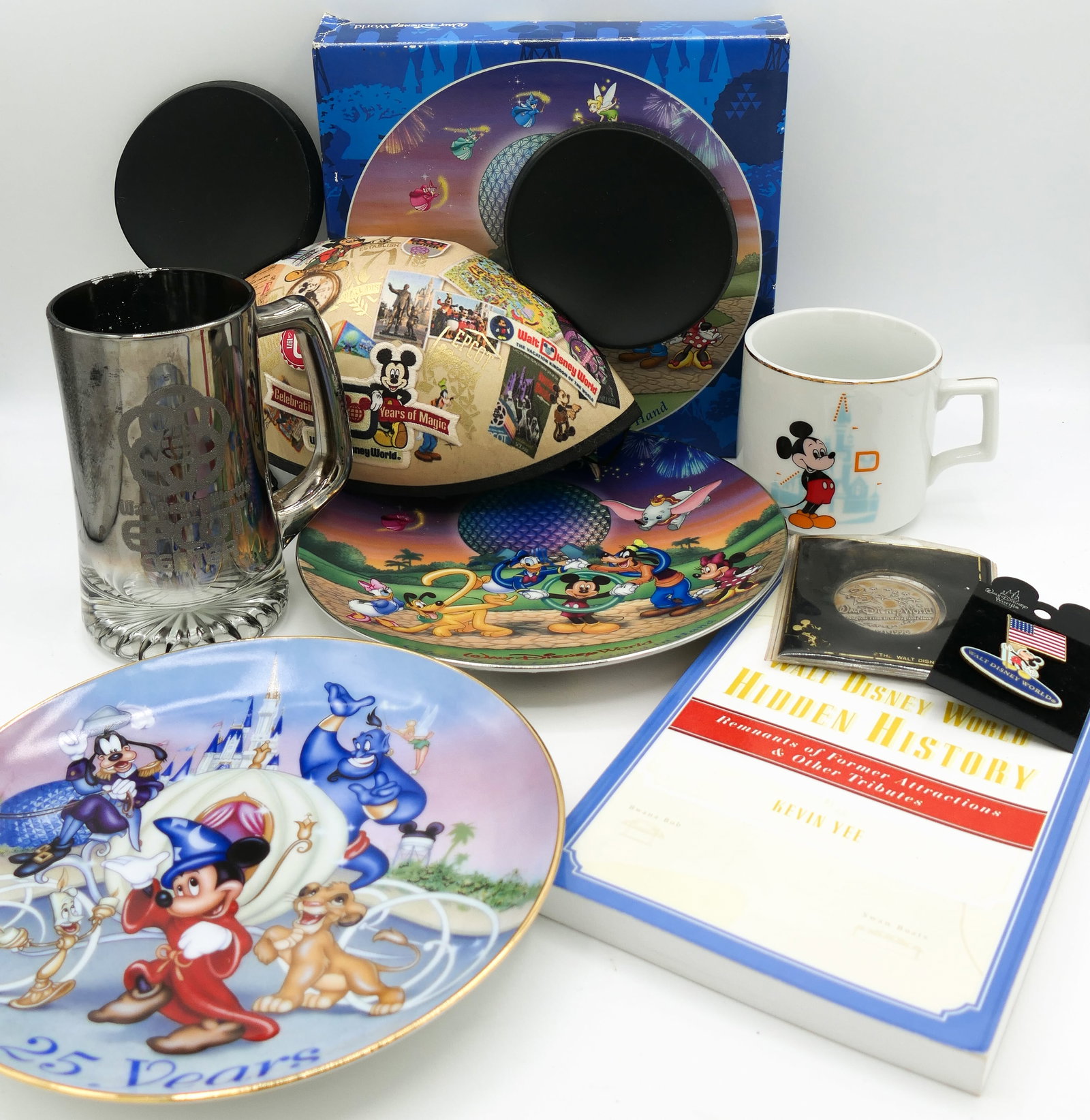 Walt Disney World Memorabilia: Walt Disney World memorabilia including a 1996 25th anniversary plate, 40th anniversary Mickey ears hat, 25th anniversary commemorative coin, 2002 trading pin depicting Mickey Mouse holding US flag,