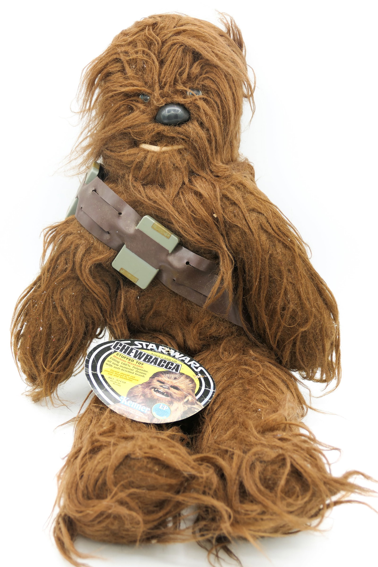 Kenner Star Wars Chewbacca Stuffed Toy: 1977 Kenner Star Wars No. 32110 Chewbacca stuffed toy wearing an ammunition bandolier sash and detached cardboard hang tag. Size: 19.5"l