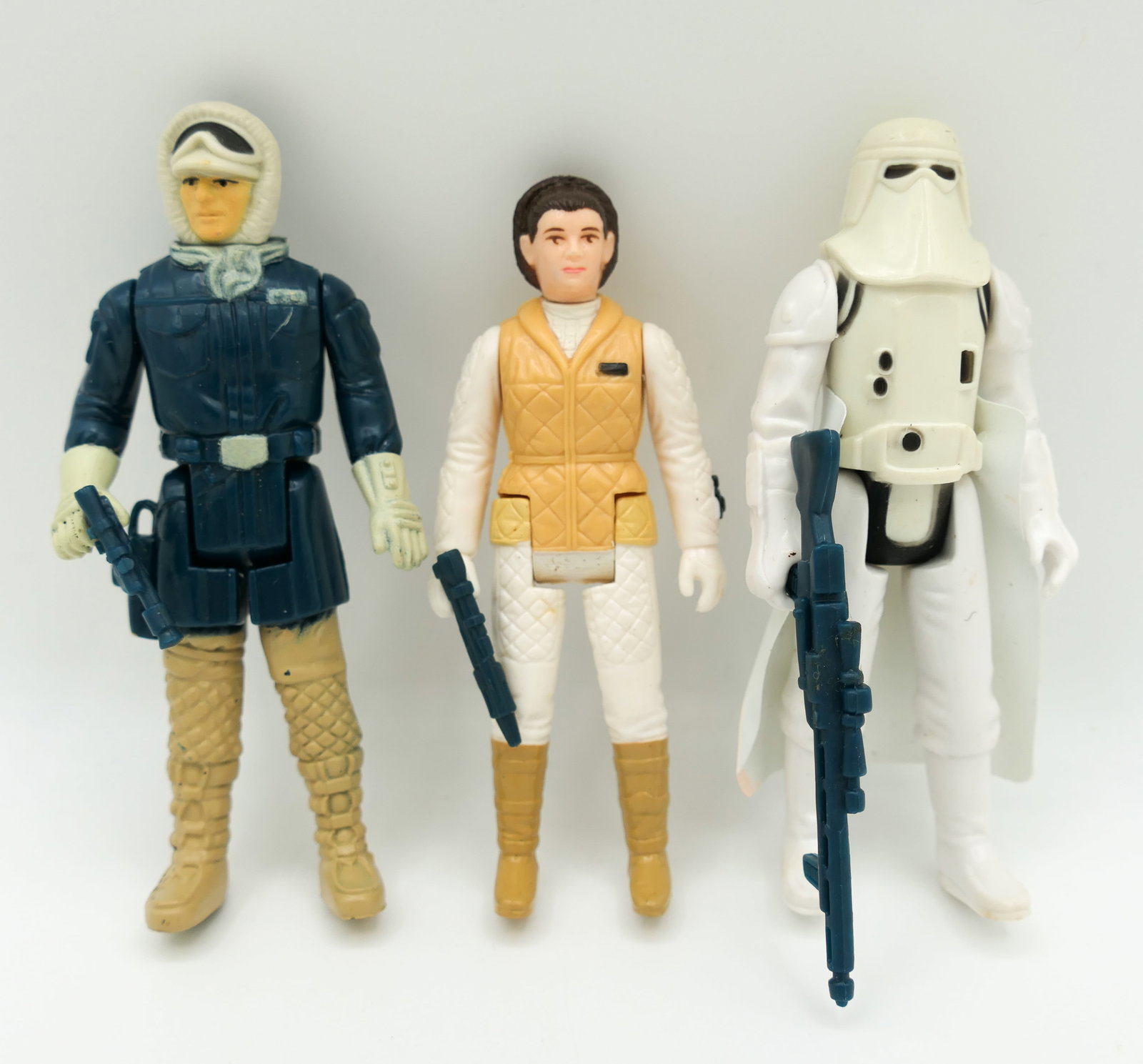 1980 Star Wars Action Figures: Three 1980 Kenner Star Wars Hoth 4 inch action figures including Han Solo, Princess Leia and Stormtrooper including some accessories. Stormtrooper has some red staining on cape. Size: 4"h