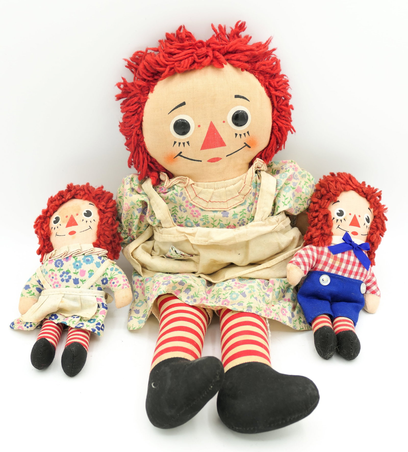 Three Vintage Raggedy Ann Dolls: Three vintage Raggedy Ann dolls, including a larger Raggedy Ann with "I love you" over the heart, and two miniature ann and andy dolls. Miniature Ann has stain on face. Slight smell from age. Size: La
