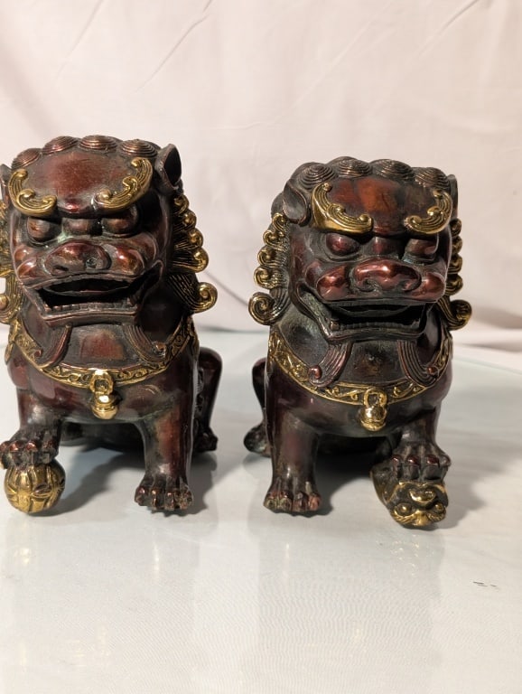 Chinese Foo Dogs Pair- Bronze / Cloisonne Accents: Chinese Foo Dogs / Imperial Guardian Lions, Pair- Bronze / Cloisonne Accents. 1950s. Exaggerated detail to face and coat. Opposite paws raised on brocade ball motif. Deep socle bases accentuated with