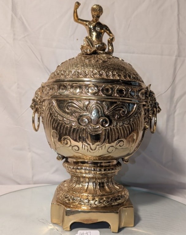 Covered Urn w/ Lid - Cast Brass Maitland Smith: Large Covered Urn w/ Lid - Cast Brass by Maitland Smith. Mid 20th century. Cherub finial at top of lid. Lion head rings on either side. Exquisitely detailed. Mint condition. On square base. Meas. 17"h