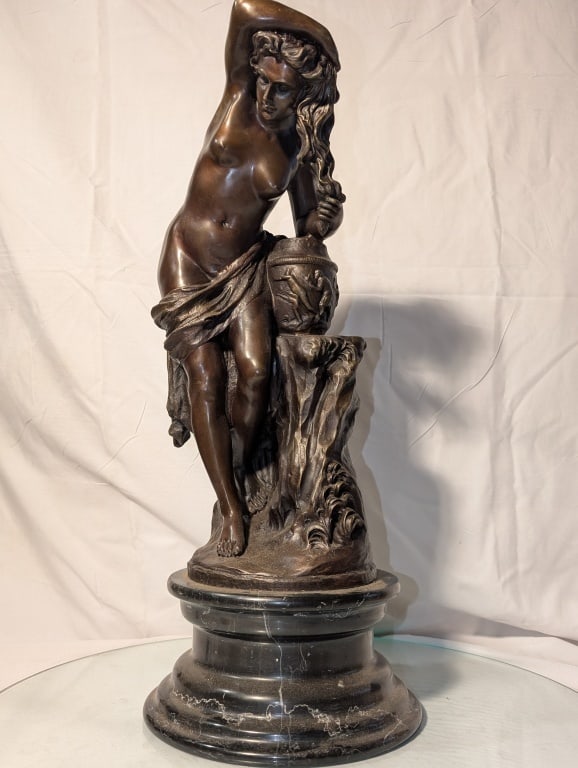 Maiden Washing Hair - Bronze on Marble Signed: Maiden Washing Hair - Bronze on Black Marble base. Signed - Lores?. Wearing a sarong w/ jug on tree trunk pedestal. Ornate design, highly detailed. Very nice piece. Meas. 20"h x 8 1/4"r