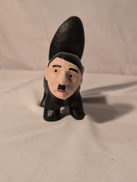 WWII CI Door Stop - Skunk "De-Phew-er": WWII CI Door Stop - Skunk w/ Facial Caricature of WWII military figure. Made in China. Anti-Furhrer Propaganda piece. 'De-Phew-er". Back of tail is marked "Mussolini" and "Hirohito" with an
