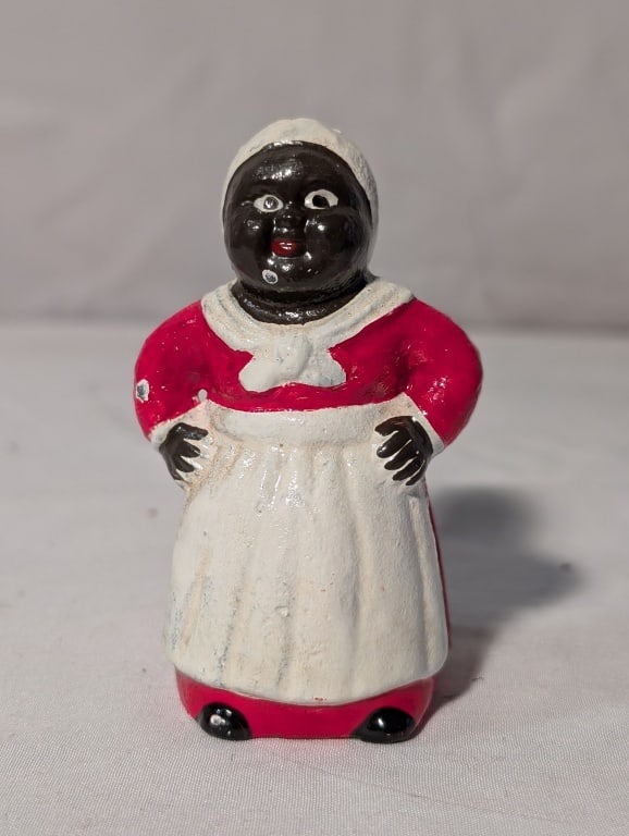 Black Americana - Mammy CI Coin Bank Miniature: Black Americana -Mammy Cast Iron Coin Bank. Miniature version. Meas. 3 1/4"h x 1 1/2"w x 1 1/2"d. Some paint loss from age. Original back screw in tact. Overall very nice.