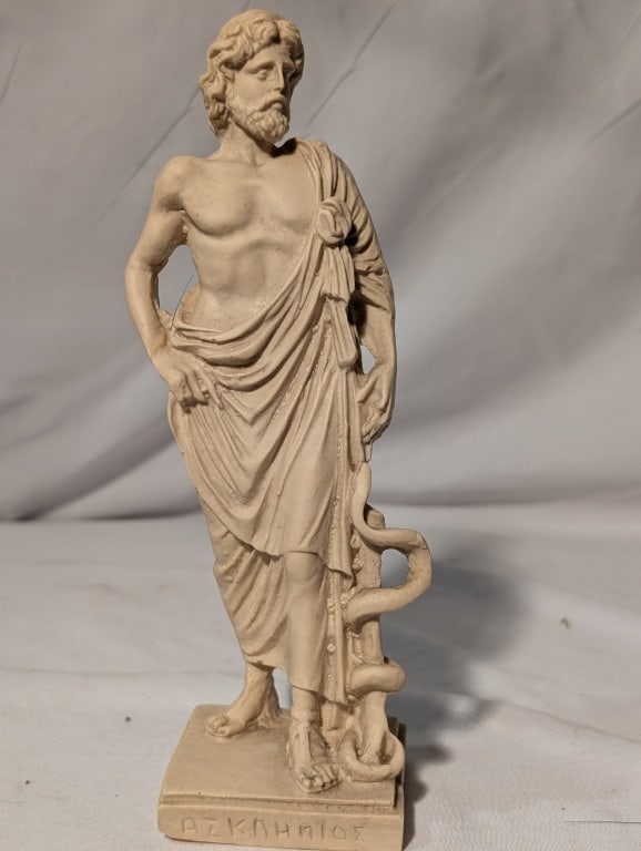 Greek Asclepios Statue - Resin w/ Antique Finish: Greek Asclepios Statue - Resin w/ Antique Finish. Based on original Greek statue of Epidaurus - God of medicine and healing. Greek writing of name on base. Meas. 8 3/4"h x 2 1/2"sq.