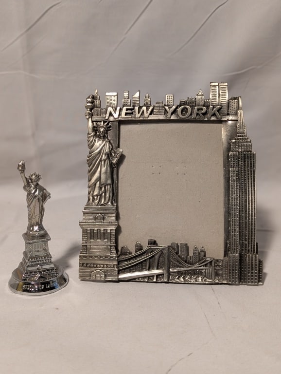 NYC Pewter Picture Frame - Landmarks & 1 Other: NYC Pewter Picture Frame - Landmarks and 1 other. Frame depicts NYC skyline featuring the Brooklyn Bridge, the Twin Towers, the Empire State Building, the Statue of Liberty. Backing shows wear.