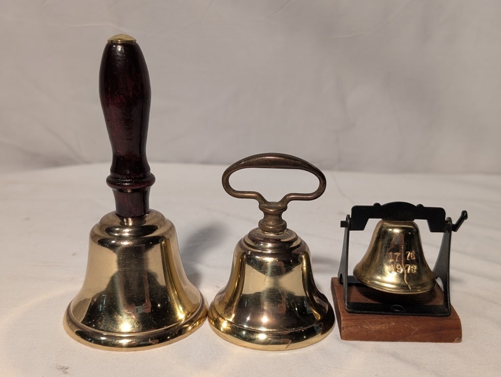 Brass Bell Collection - Set of 3: Brass Bell Collection - Set of 3. Brass dinner bell w/ wooden handle w/ number etched in well. Brass hotel bell w/ finger loop. Brass Liberty Bell (1776/1976 bicentennial miniature souvenir on wooden