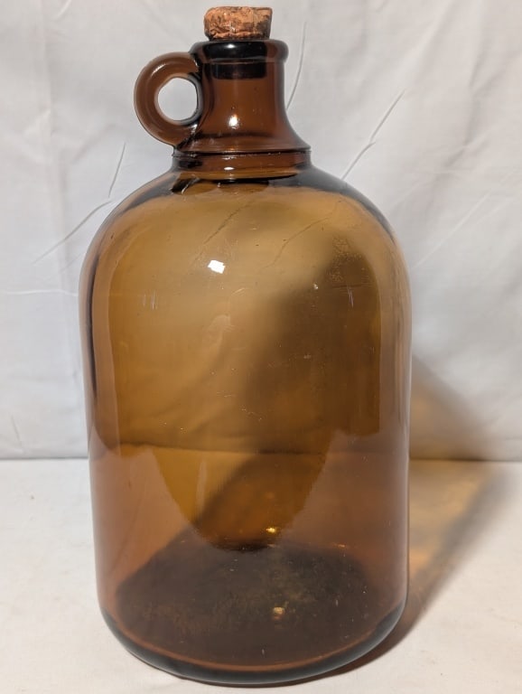 Amber Whiskey Bottle w/ Cork Gallon Jug: Amber Whiskey Bottle w/ Cork Gallon Jug. Pressed glass with finger ring. Imported by John Wyeth, Phila. Rough pontil w/ some chipping around pontil. Meas. 11 3/4h x 6 1/4r