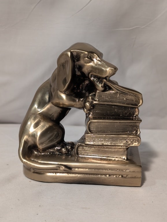 Bronze Bookend Dachshund Chewing on a Book: Bronze Bookend / Door Stop / Paperweight - Dachshund Eating a Book atop of stack of books. By PM Crafts USA. Label on felt bottom base. Meas. 5 1/2:h x 4 1/2"w x 2 1/4"d