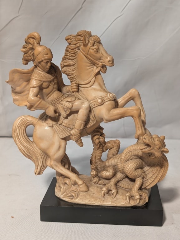 St. George and the Dragon Statue - G. Ruggeri: St. George the Roman Dragon Slayer Atop Horse Statue. Signed G.. Ruggeri. Resin statue with very nice detail. The metal spear is missing. On black wood base. Meas. 7 1/2:h x 2 3/4"w x 4 3/4"d