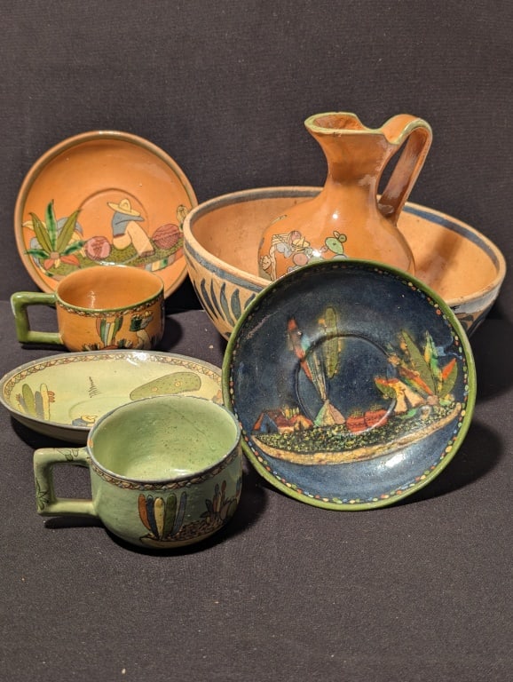 Mexican Pottery Grouping: Mexican Pottery Collection includes a handmade bowl with natural glaze , blue accents. Meas. Bowl 4"h x 9"r. Pitcher has desert scene w/ blue/green/yellow coloring. meas. 7"h x 5"r. 2 cups w/