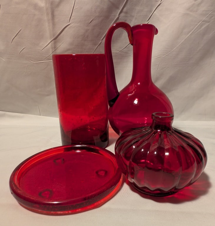 Ruby Red Glass Collection - 4 pieces: Ruby Red Glass Collection - 4 pieces. Pitcher has swan neck handle w/ pedestal base an meas. 8"h x 4"r. Bouquet vase w/ wide opening. Meas approx 7"h x 3"r. Small ribbed bud vase meas.4"h x 4"r