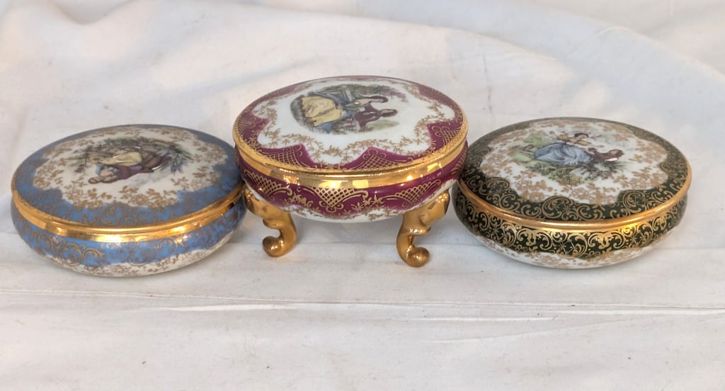 Limoges Trinket Boxes - Porcelain, Stamped: Limoges Trinket Boxes - Porcelain, Stamped. Set of 3. All have Victorian design. 1 has a red base and is footed w/ detachable lid. Has gold leaf accents and meas. 2"h x 3"r. 1 has a green base / detac