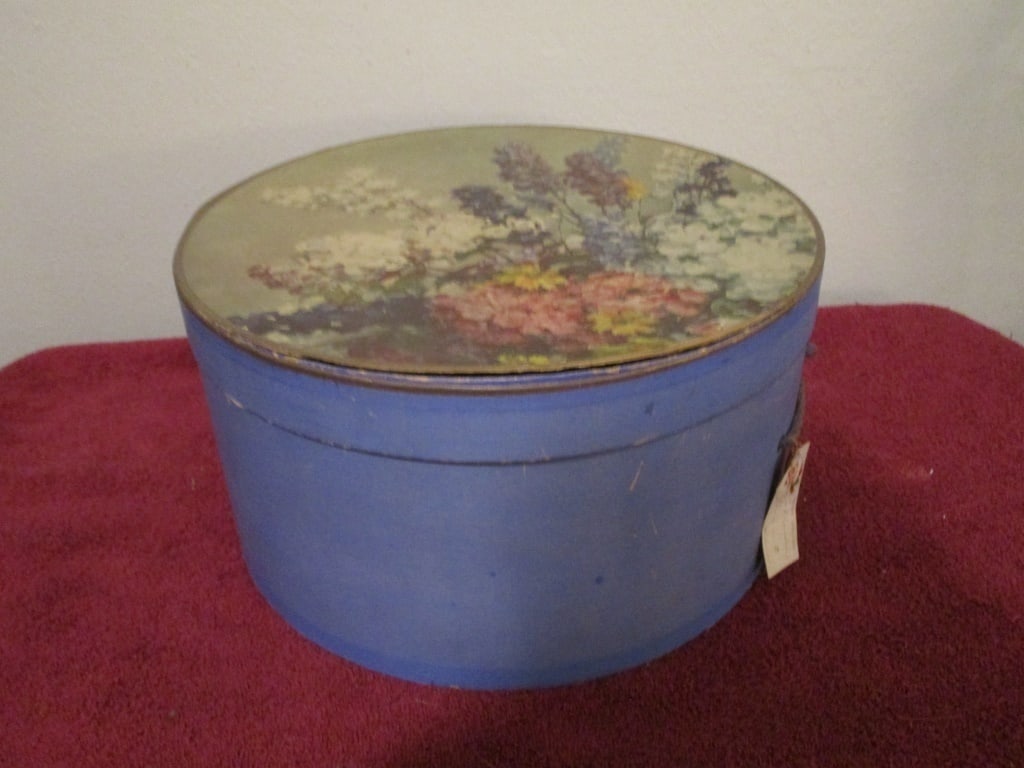 1940s Hat Box, Blue Floral Lid, Cardboard: 1940s Hat Box, Blue Floral Lid, Solid all cardboard w/ blue base w/ original tissue paper and Christmas gift tag. Original blue rope. Some discolored and marks due to age. Box bottom is not attached. 