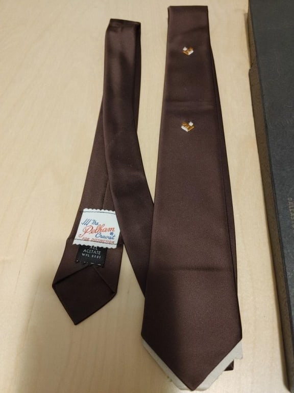Vtg DeVono's The Pelham Cravat / Tie: Vtg DeVono's The Pelham Cravat / Tie, Dallastown, PA. Brown w/ white and copper embroidered geometric design. 100% acetate in original box and packaging. Meas. 25" folded.