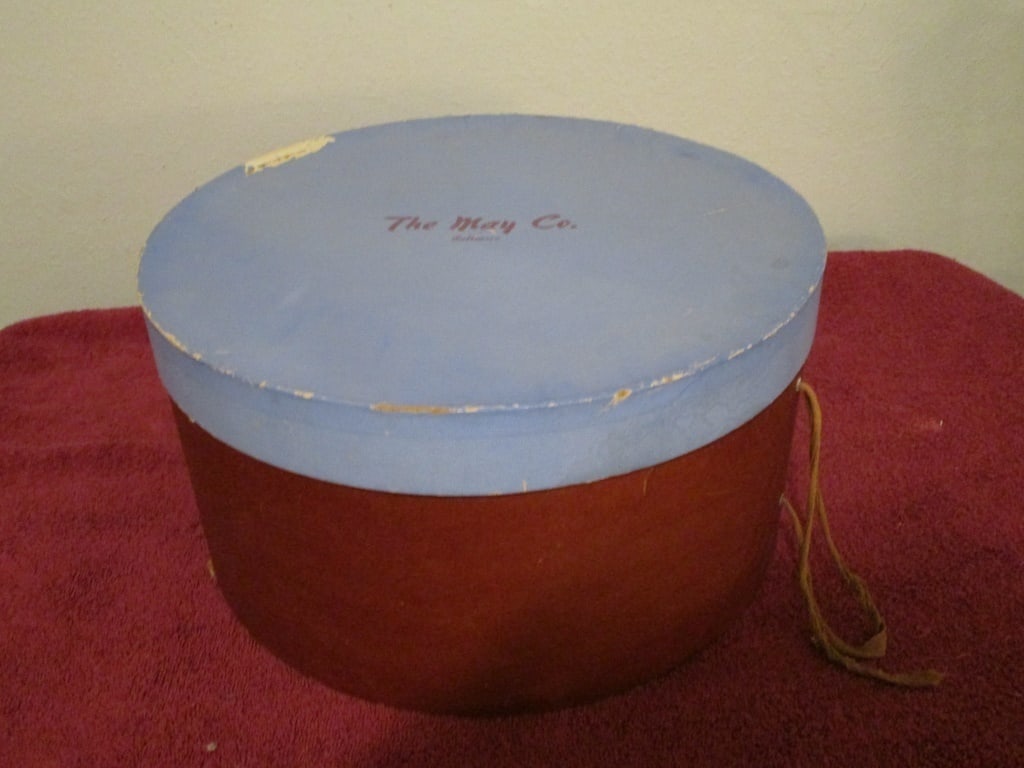 1940s Hat Box, The May Co Baltimore: 1940s Hat Box, The May Co Baltimore. Lid is cornflower blue, base is brown. Some loss / scratches on lid, minor discoloration and some scratches due to age. Bottom has some separation. Original rope a