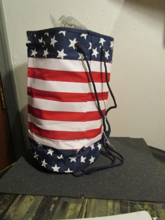 Flag Design Barrel Backpack / Tote Bag: Flag design Barrel Backpack / Tote Bag with blue rope straps, vinyl, red/white/blue, stars & stripes, drawstring strap closure. Like new. Meas 15"h x 14"w