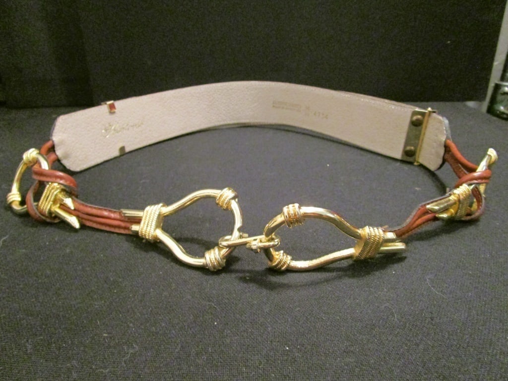 Adj. Leather Belt w/ Brass Accents Argentina: Adj. Leather Belt w/ Brass Accents Thaktoosh, Argentina. V734. Hook close, brass slides, brass leather loops. Meas 36"