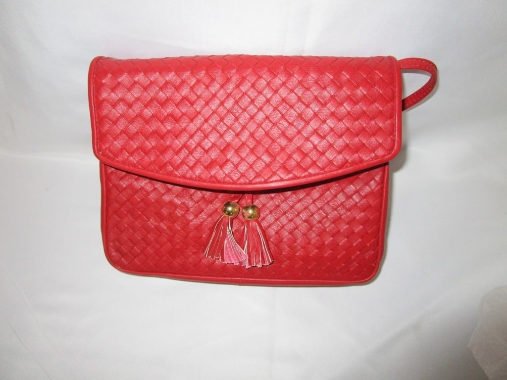 Vtg Ganson Red Leather Basket-weave Shoulder Bag: Vtg Ganson Red Basket-weave Shoulder Bag w/ brass and tassle accents. All leather. Front fold magnetic clasp, 2 interior pockets - one with zippered pocket. Leather strap. Meas. 9"w x 7"h x 2 1/2"d. S