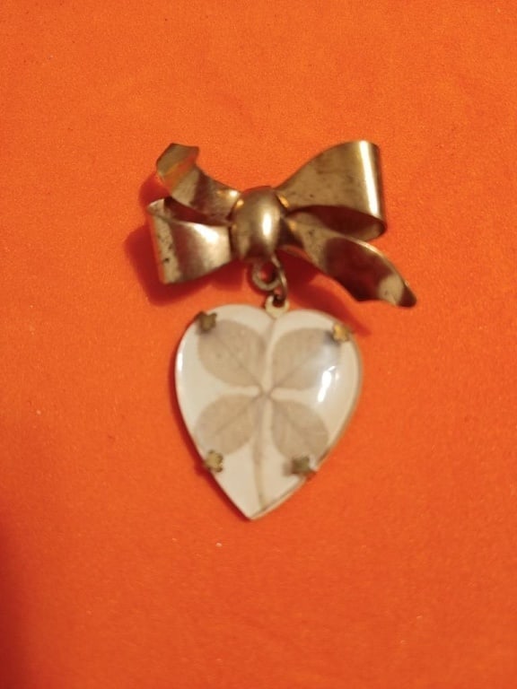 Antique Brooch w/ Real 4-Leaf Clover: Antique Brooch w/ Real 4-Leaf Clover. Gold plated with dangling clover set in glass heart. Brooch is a bow. Nicely patinated. Beautifully preserved. Ripples in leaves are visible.