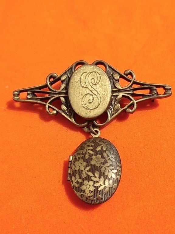 Antique Brooch w/ Dangling Locket: Antique Brooch w/ Dangling Locket. Gold plated. Locket inscripted with an "S" scroll design. Meas. 2" 1/4"h x 2"w. Well patinated, beautiful piece.