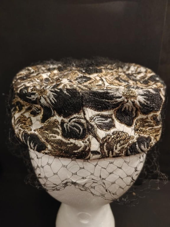 1940s Modern Miss Hat Cream Base w /Black & Gold: 1940s Modern Miss Hat Cream Base w /Black & Gold floral design w/ scattered black bead accents on light cream base. Black mesh face covering. All bead in tact. Original label. Near mint condition. Mea