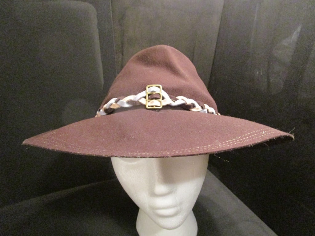 1970s Gaucho Felt Brown Hat: 1970s Gaucho Felt Brown Hat w/ Consumer Protections label 23. Light blue, tan, brown band w/ metal slide accent. Collapsible. Triple stitched brim. Some minor markings. Very nice condition. Meas 12"r 