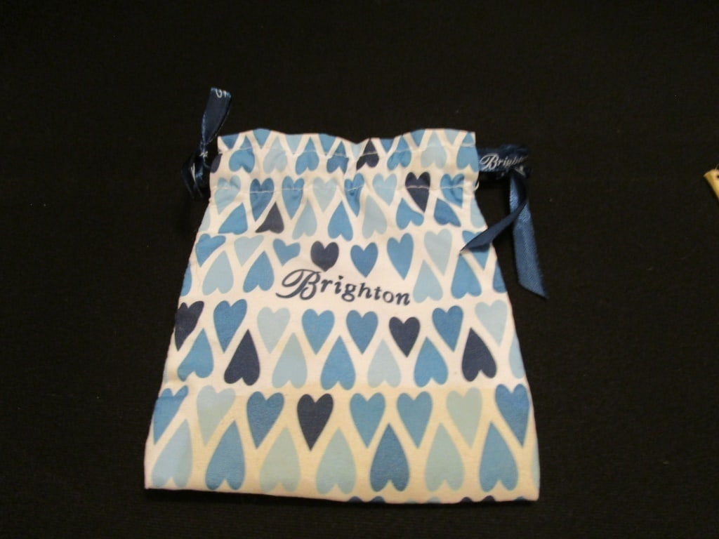 Vtg Mini Brighton Logo Drawstring Cloth Bag: Vtg Mini Brighton Logo Drawstring Cloth Bag. Blue heart design on white background. Blue Brighton ribbon drawstring. Meas 5"w x 6"h. Mint condition.