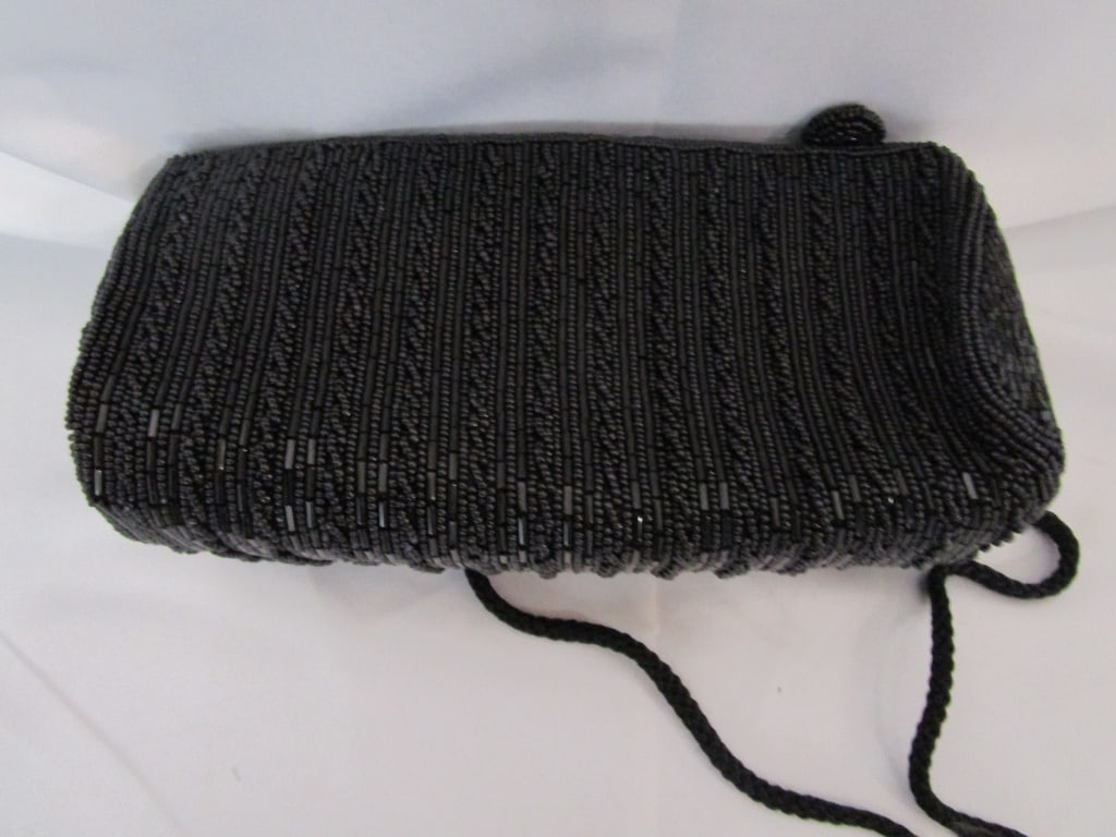 Vtg Black Beaded Clutch / Evening Bag w/ Strap: Vtg Black Beaded Clutch / Evening Bag w/ shoulder strap. Zippered close w/ interior side pouch. No missing beads, in mint condition. Meas. 8"w x 5"h x 3"d. Strap meas 24"l.