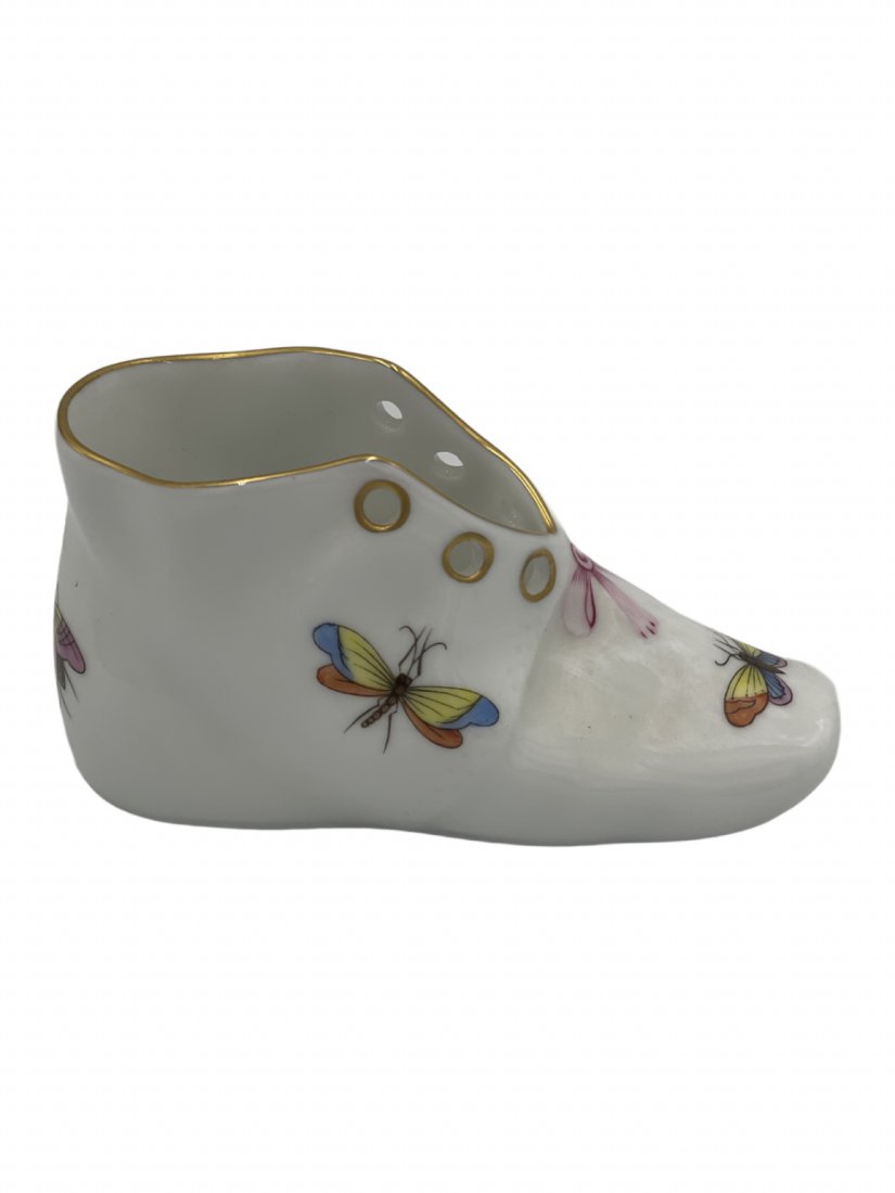 Herend Hungary Porcelain Baby Shoe: This porcelain baby shoe is hand painted by maker Herend Hungary. It has 24K gold painted accents. The shoe measures 2 inches tall, 4 inches long, and 1/2 inch wide. It weighs 3.6 oz.