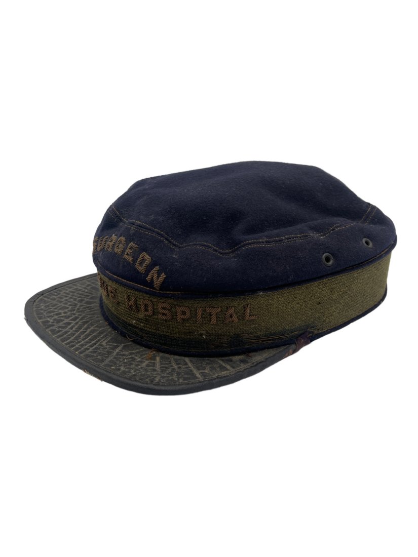 Antique Surgeon Hat: This Antique surgeon hat comes from the Bellevue Hospital. It is likely from the early 1900s. The hat is a navy blue wool with a black brim. There is some slight bending to the brim of the hat due to