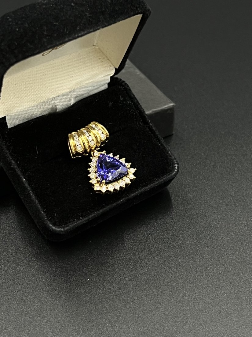 Stunning 18kt. Gold Tazanite & Diamond Enhancer: Stamped 18kt. yellow gold Tanzanite & Diamond Enhancer. Triangular cut Tanzanite measures 12.50mm x 12.00mm x 7.40mm, formula 7.84 carats. Tanzanite is purple blue in hue, medium in tone and strong in