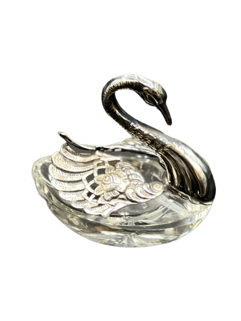 Sterling and Crystal Swan Salt Cellar: Sterling silver and crystal swan salt cellar with movable wings. Swan head is curved downward, and the wings are decorated with a floral rose. Length is roughly 2.75 inches, height is 3 inches. Lot we